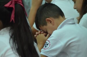 Niños Haciendo oración durante la misa